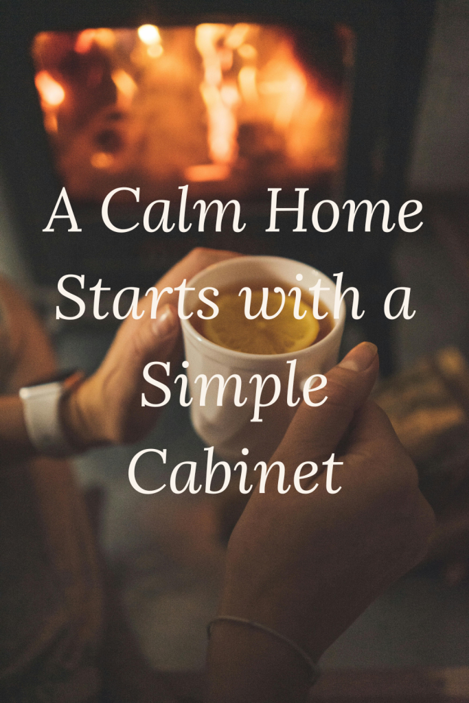 Hands holding a warm cup of tea near a fire, symbolizing comfort and a calm home environment.