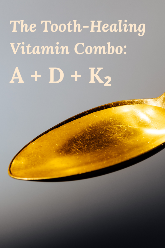 Close-up of golden spoon on gray background with text “The Tooth-Healing Vitamin Combo: A + D + K2.”